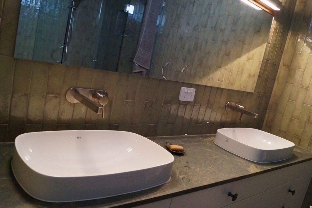 Modern bathroom vanity with two white above counter basins, wall mounted taps and water efficient plumbing fixtures in an Albury Wodonga home
