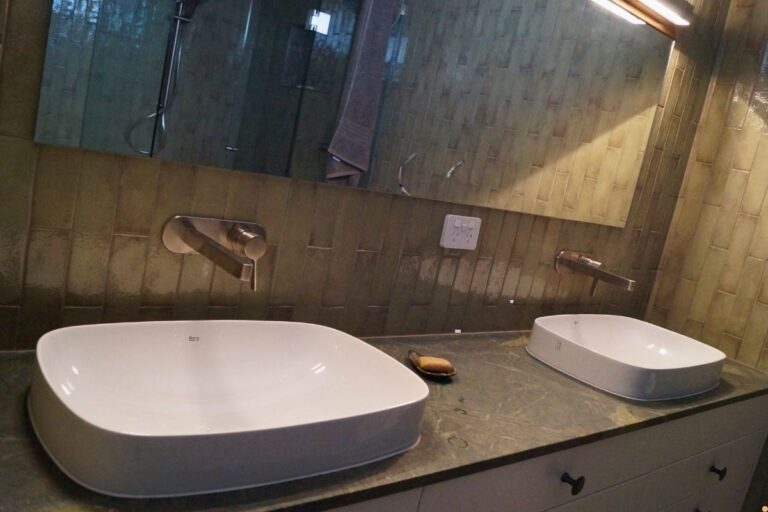 Modern bathroom vanity with two white above counter basins, wall mounted taps and water efficient plumbing fixtures in an Albury Wodonga home