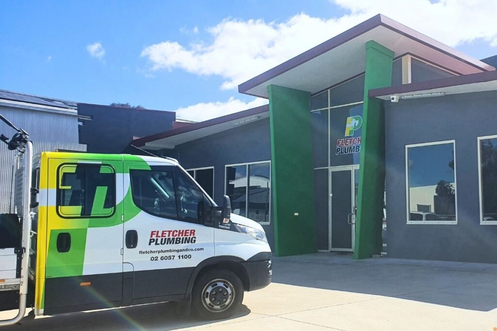 Fletcher Plumbing van parked outside their Albury Wodonga office, displaying contact number and website